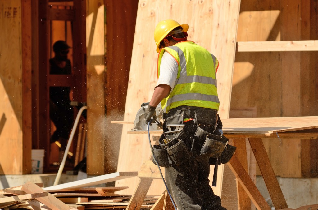 Carpenter using a saw to cut a wood