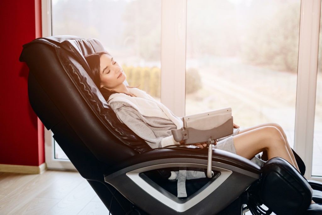 woman relaxing on the massaging chair at home