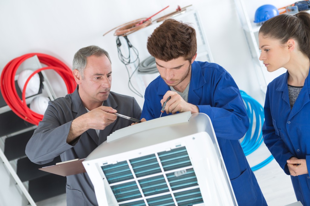 men repairing aircon