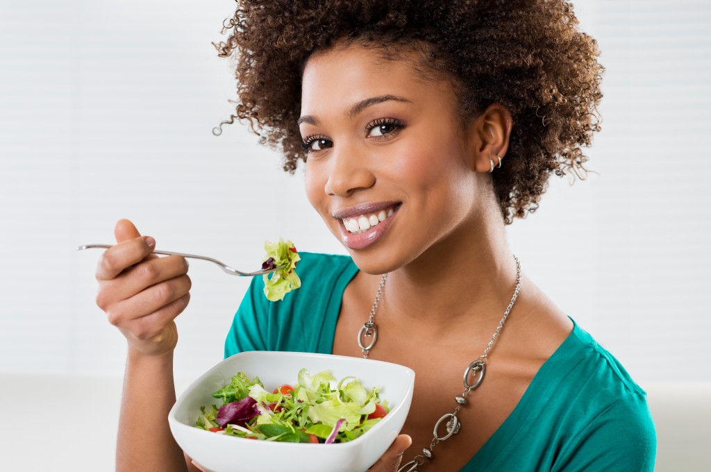 Woman eating salad in a bowl