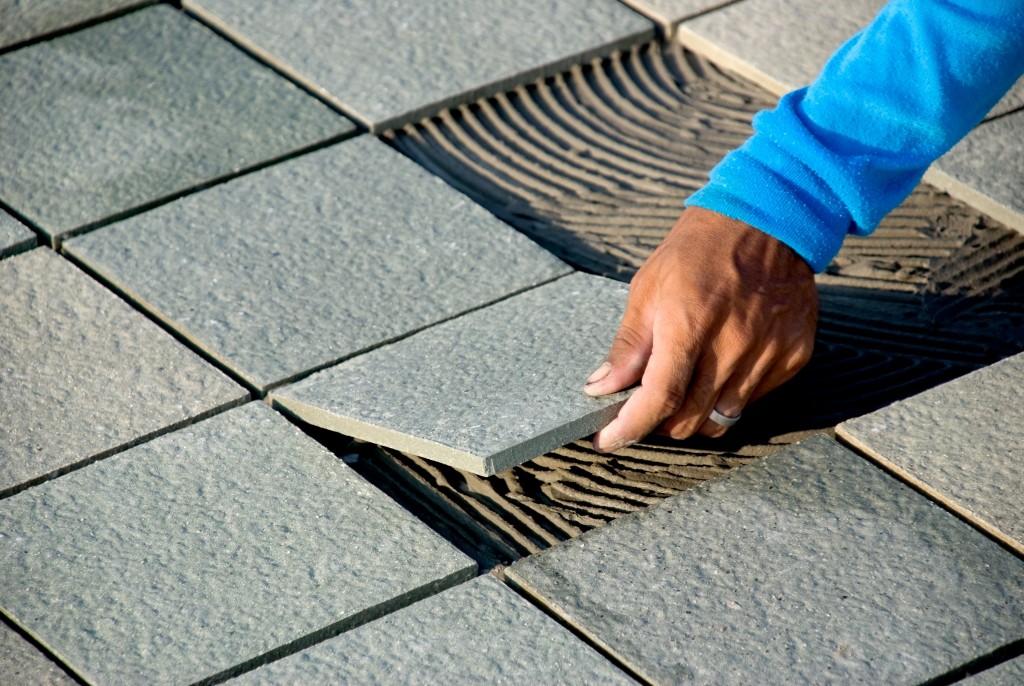 man installing floor tiles