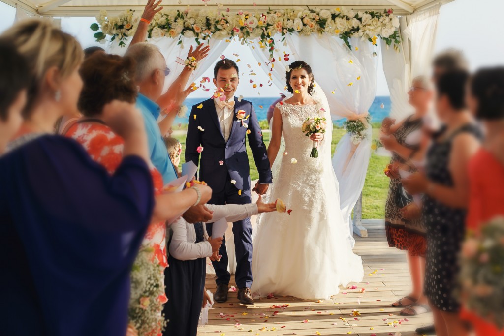 smiling newlyweds on the luxury outdoor wedding ceremony in haze tent near the ocean