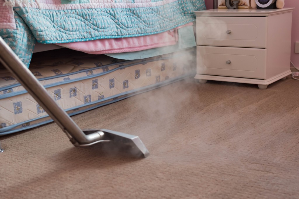Vacuuming the floor of bedroom