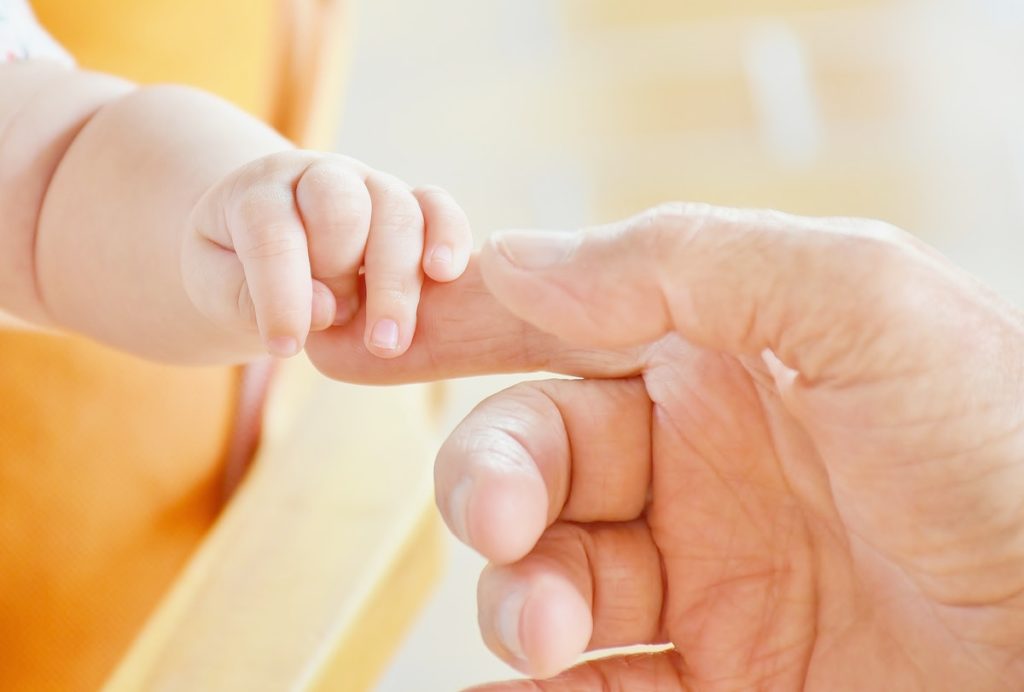 Child holding adult's finger