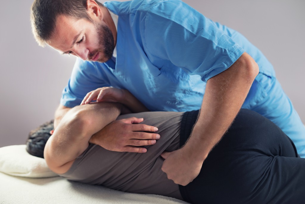 Chiropractor popping back of patient