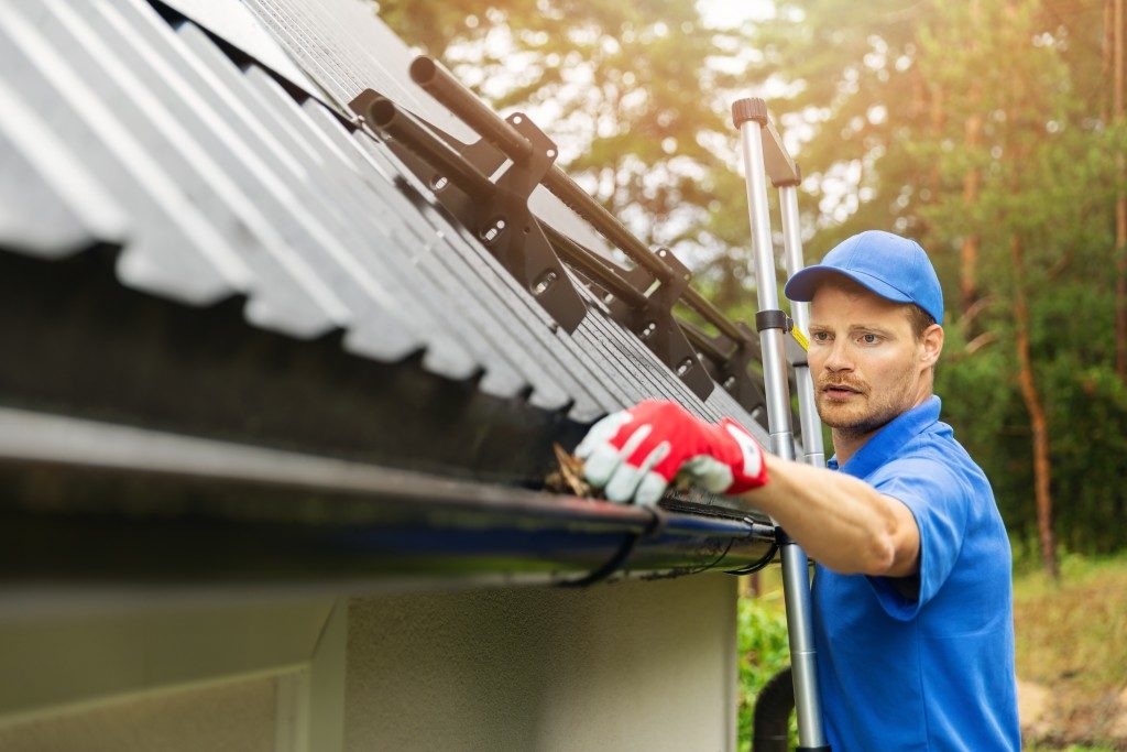 man cleaning the roof gutter