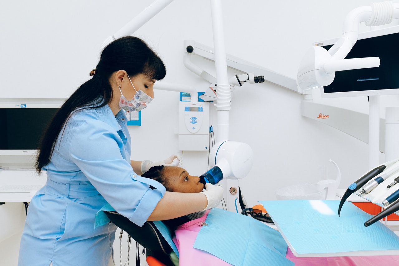 dentist looking at the teeth of her patient