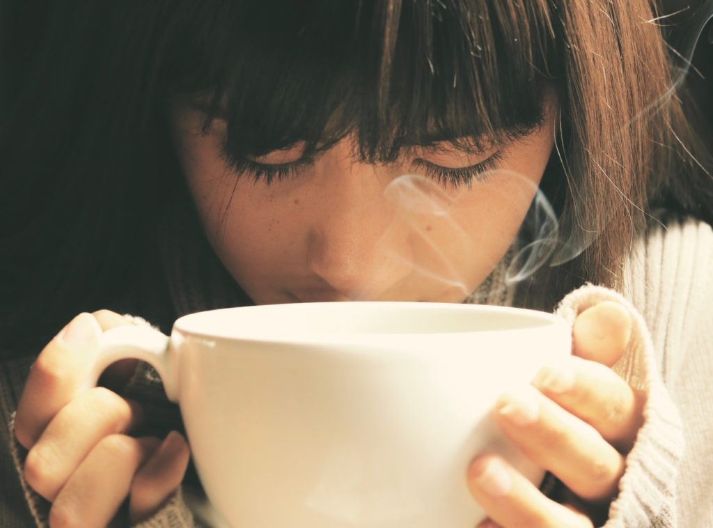 woman holding large cup of coffee