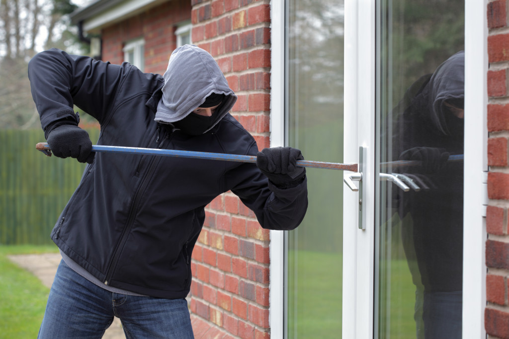 man breaking in with crowbar