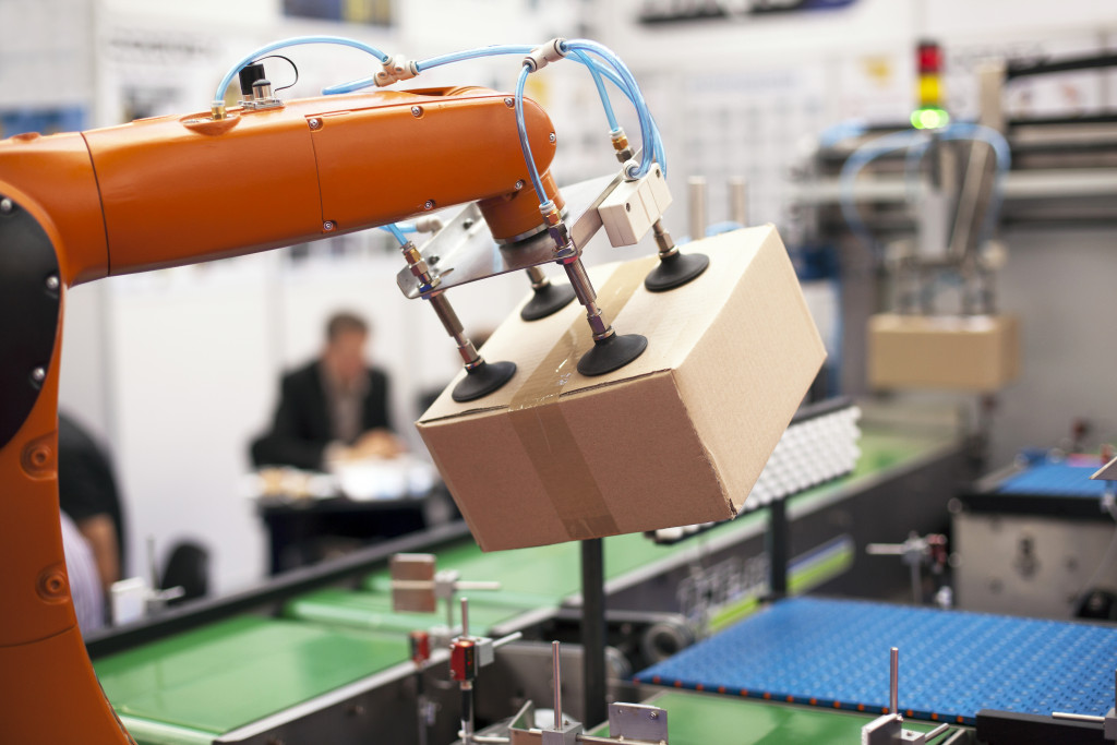 robotic arm picking up a packaged box from a conveyor belt