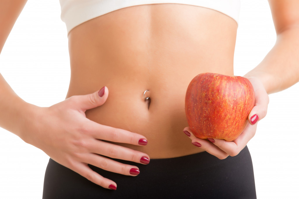 healthy stomach and an apple in hand