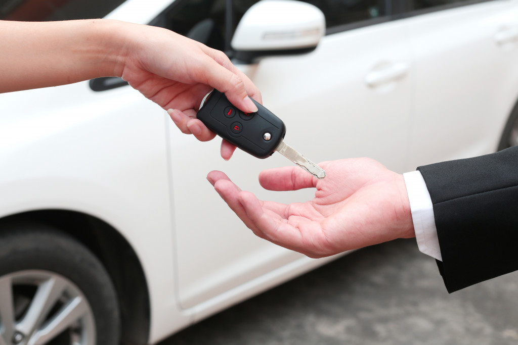a person handing out a car key